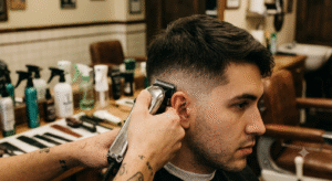 Barber creating a sharp skin fade haircut on a male client at a barbershop in NYC.